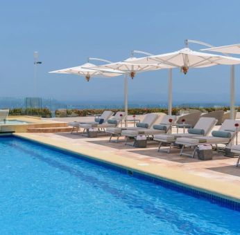 Outdoor pool with pool loungers at Grand Miramar All Luxury Suites & Residences.