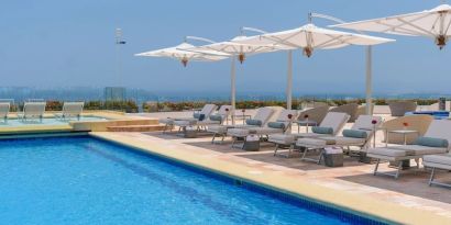 Outdoor pool with pool loungers at Grand Miramar All Luxury Suites & Residences.