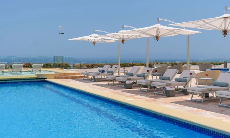 Outdoor pool with pool loungers at Grand Miramar All Luxury Suites & Residences.