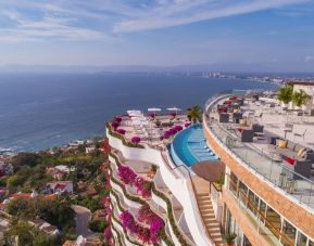 Hotel exterior with pool and ocean view at Grand Miramar All Luxury Suites & Residences.