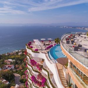 Hotel exterior with pool and ocean view at Grand Miramar All Luxury Suites & Residences.