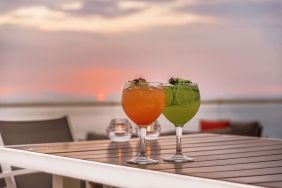 Outdoor terrace and drinks at Grand Miramar All Luxury Suites & Residences.