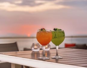 Outdoor terrace and drinks at Grand Miramar All Luxury Suites & Residences.