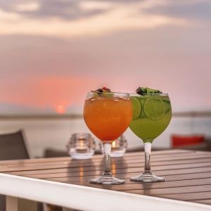 Outdoor terrace and drinks at Grand Miramar All Luxury Suites & Residences.