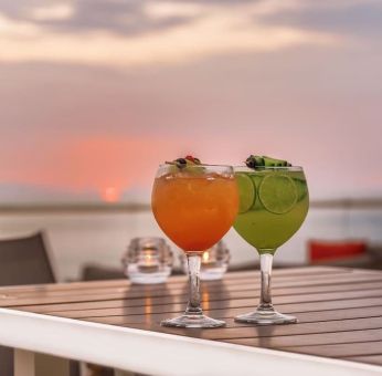 Outdoor terrace and drinks at Grand Miramar All Luxury Suites & Residences.