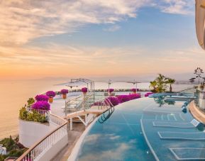 Outdoor pool with pool chairs at Grand Miramar All Luxury Suites & Residences.