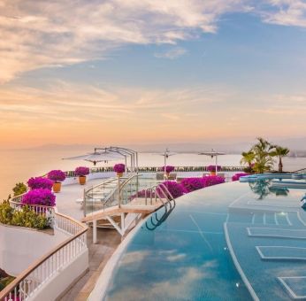 Outdoor pool with pool chairs at Grand Miramar All Luxury Suites & Residences.