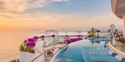 Outdoor pool with pool chairs at Grand Miramar All Luxury Suites & Residences.