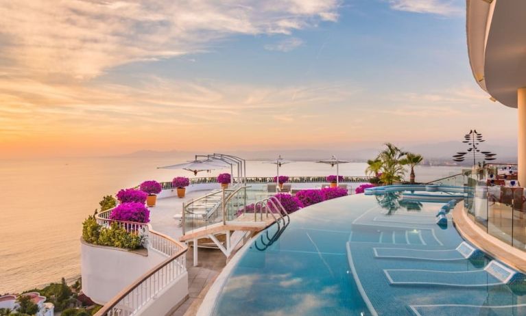 Outdoor pool with pool chairs at Grand Miramar All Luxury Suites & Residences.