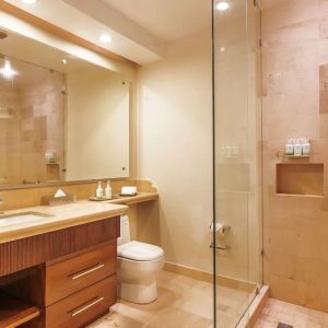 Guest bathroom with shower at Grand Miramar All Luxury Suites & Residences.