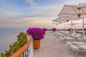 Outdoor terrace with pool chairs at Grand Miramar All Luxury Suites & Residences.