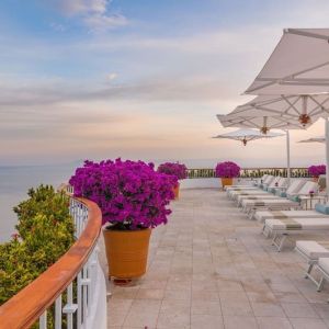 Outdoor terrace with pool chairs at Grand Miramar All Luxury Suites & Residences.