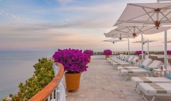 Outdoor terrace with pool chairs at Grand Miramar All Luxury Suites & Residences.