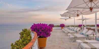 Outdoor terrace with pool chairs at Grand Miramar All Luxury Suites & Residences.