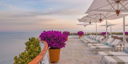 Outdoor terrace with pool chairs at Grand Miramar All Luxury Suites & Residences.