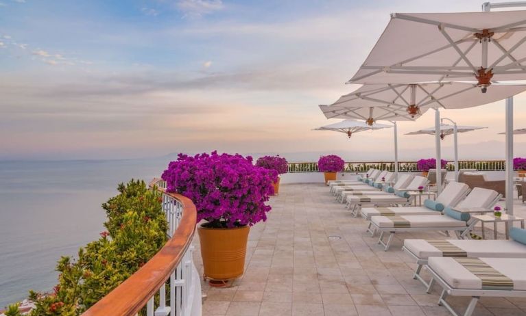 Outdoor terrace with pool chairs at Grand Miramar All Luxury Suites & Residences.