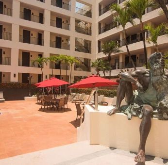 Outdoor pool and seating area at Hotel Delfin PV Beach Resort.