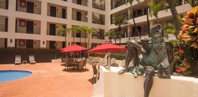 Outdoor pool and seating area at Hotel Delfin PV Beach Resort.