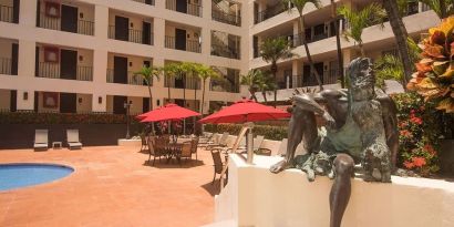 Outdoor pool and seating area at Hotel Delfin PV Beach Resort.