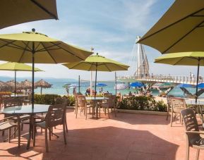 Outdoor seating with beach umbrellas at Hotel Delfin PV Beach Resort.