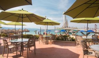 Outdoor seating with beach umbrellas at Hotel Delfin PV Beach Resort.