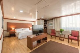 Spacious king room with TV at Suites Perisur Furnished Apartments.