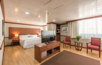 Spacious king room with TV at Suites Perisur Furnished Apartments.