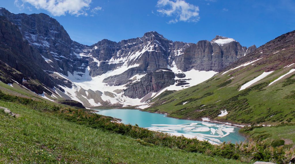 Cracker Lake running through mountains and green hills in Glacier National Park-Montana.