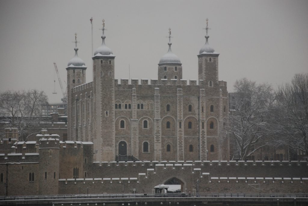 The historic Tower of London in the grey dreary winter covered in snow.