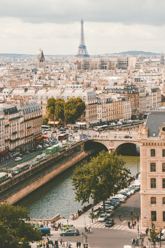 Grey hazy summer day in Paris overlooking the canal with Eiffel Tower and Notre-Dame de Paris in the backdrop.