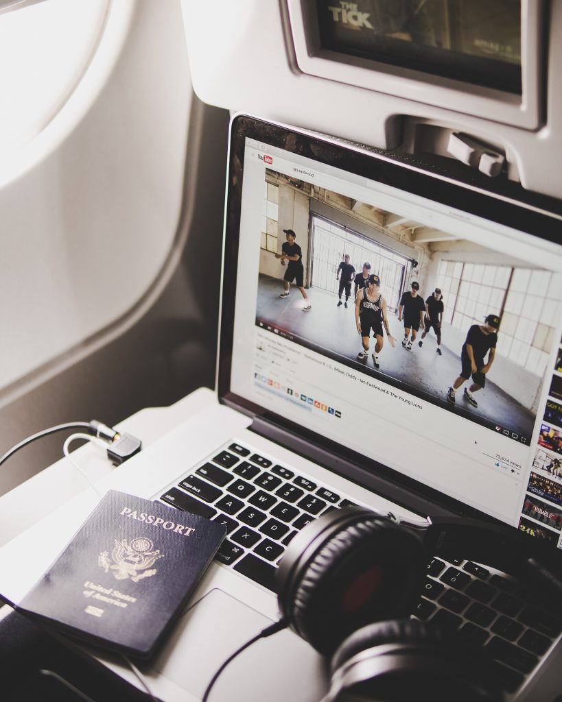 Passenger watches a Youtube video on airplane tray table during a long flight.